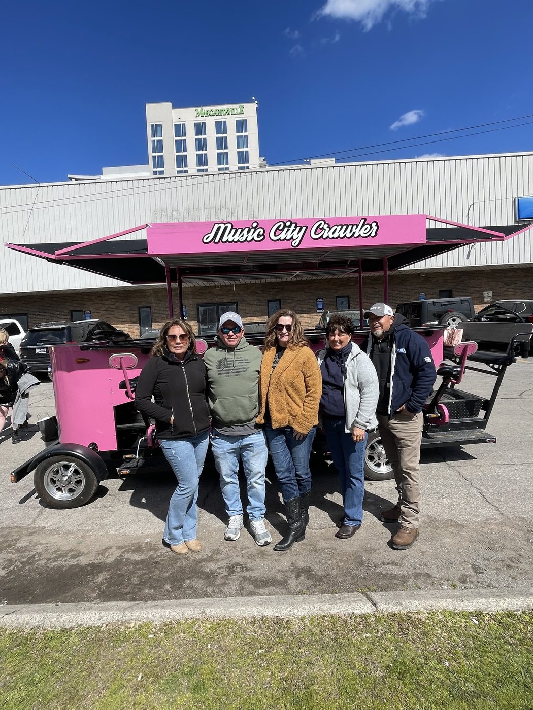 A group of coworkers in front of the Music City Crawler party bike